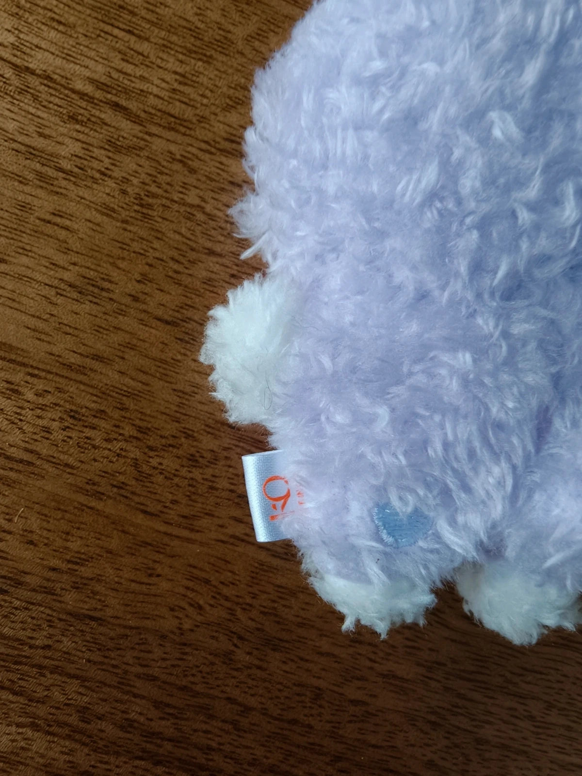 ATEEZ Aniteez Sandeoki Plush Keyring San, close-up of the fabric label and tail