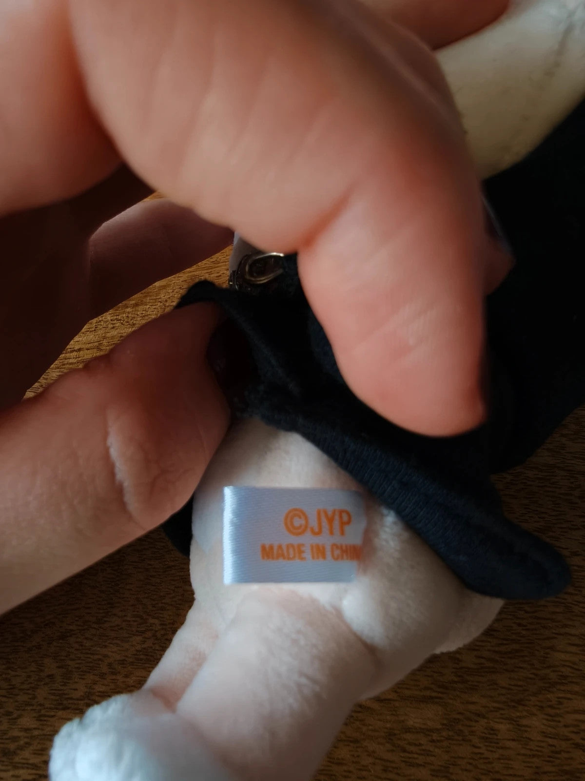 Stray Kids SKZOO FoxI.Ny Plush (Victory), close-up of the fabric label under the black shirt