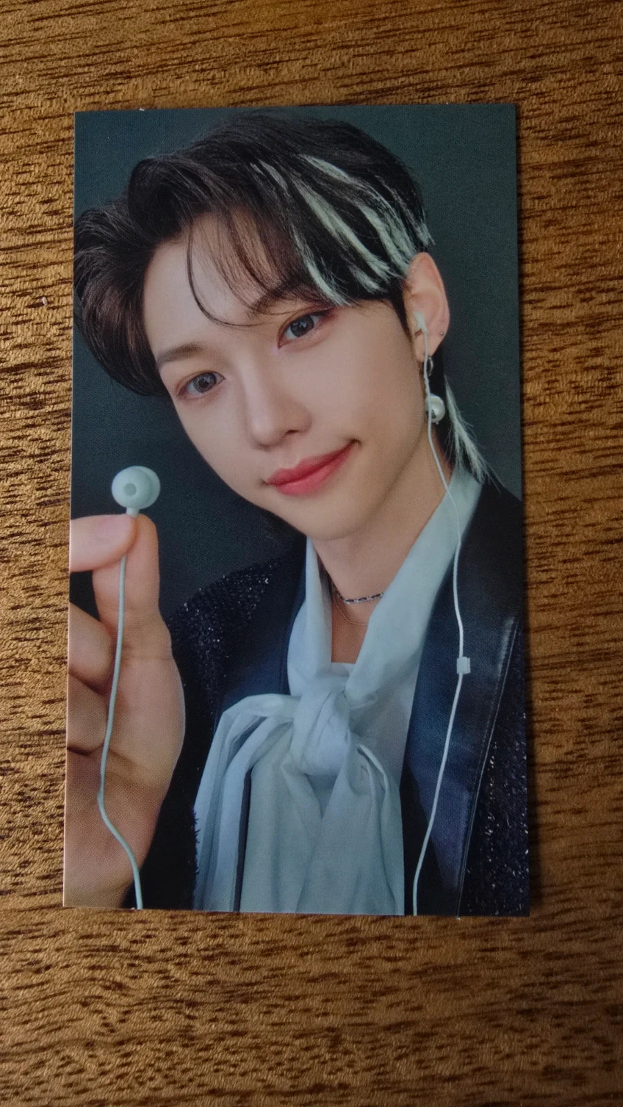 Stray Kids The Sound Photocard Felix, portrait in a pale blue shirt holding a small round prop